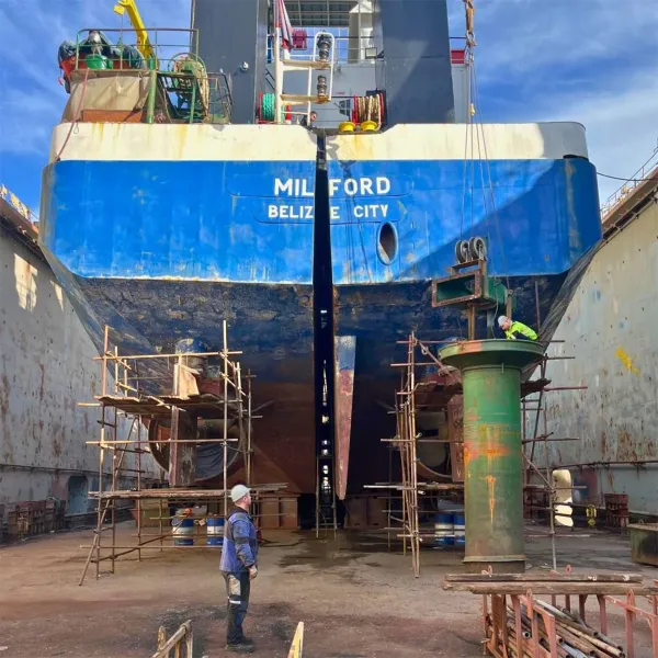 Ship repair team working in dry dock around the vessel stern and hull area