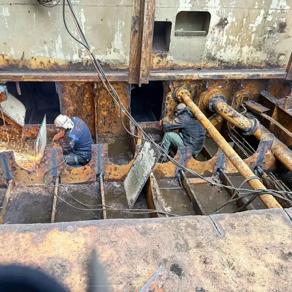 Ship repair team carrying out hull steel renewal in a corroded vessel structure