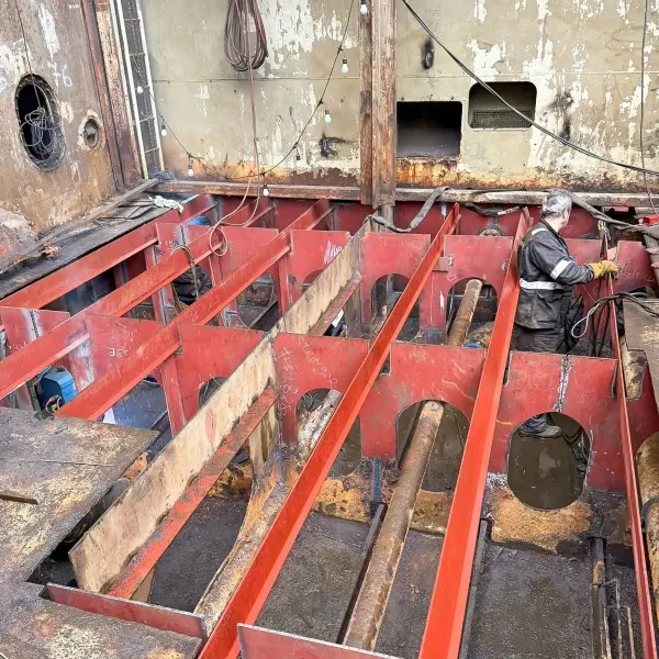 Steel worker carrying out internal hull structure steel renewal inside a vessel