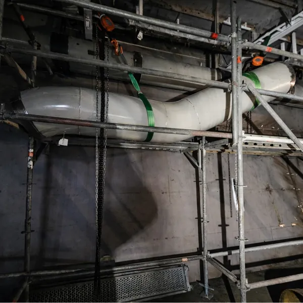 Large-diameter pipe section positioned for onboard ship piping installation