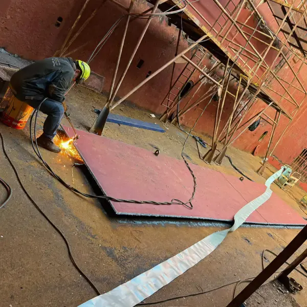 Welder carrying out steel plate welding during ship repair and dry dock support works.
