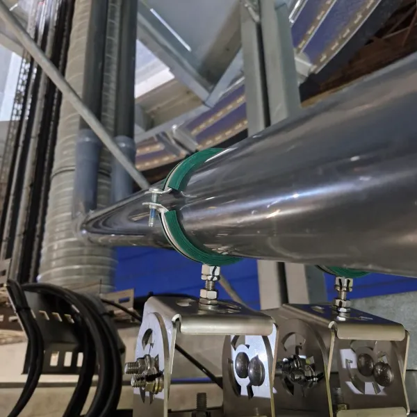 Stainless steel industrial process piping installed with clamps and supports