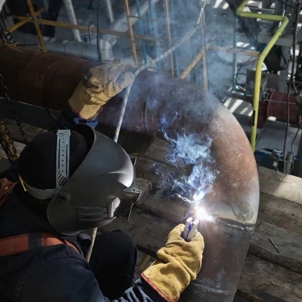 Welder performing steel pipe welding